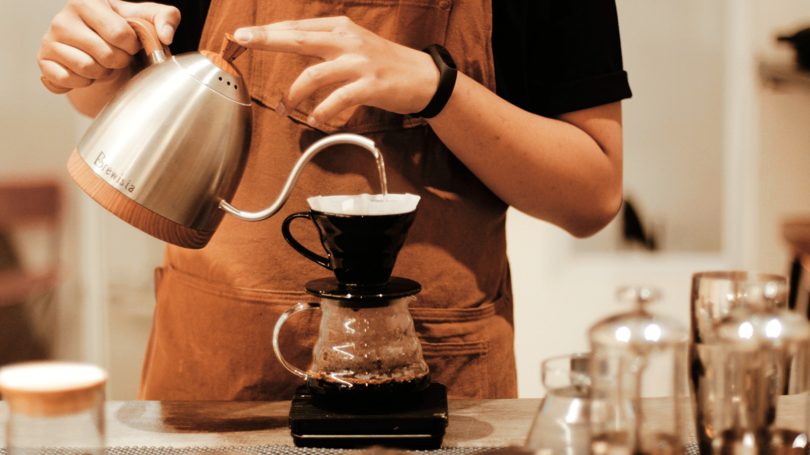 Barista brewing pourover coffee